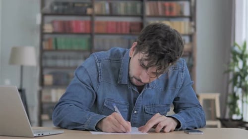 Young Adult Focused Writing at Desk Indoors