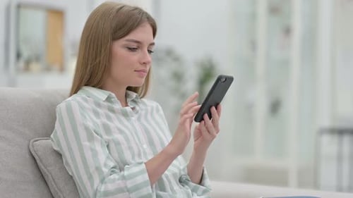 Woman Using Mobile Phone Relaxing on Couch
