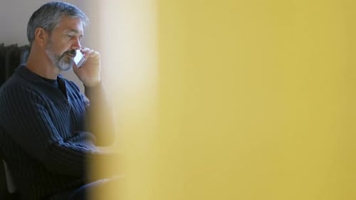 Mature Man Using Phone and Tablet Indoors