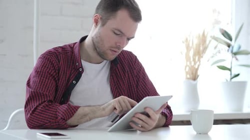 Young Adult Shopping Online with Tablet and Card