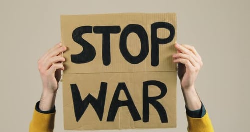 Junge im gelben Hemd hält Stop-War-Werbetafel in der Hand