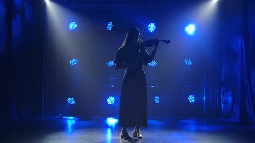 Violinist Playing Violin on a Blue Lit Stage