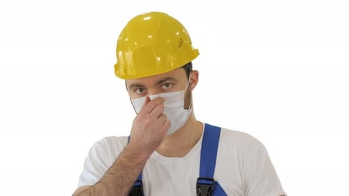 Construction Worker Adjusts Face Mask and Looks Ahead