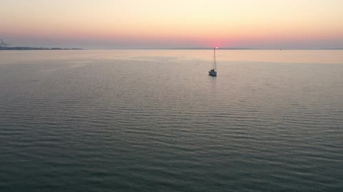 Boat in the Middle of Calm Sea Waters and the Beautiful Sunset in the Sky