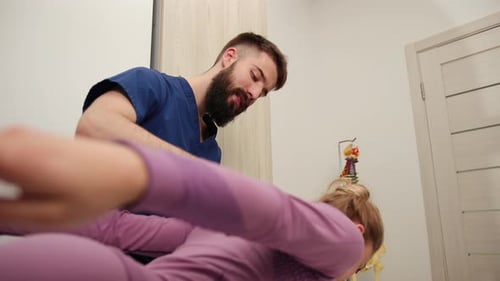 Man Massaging Woman's Back in Doctor's Office