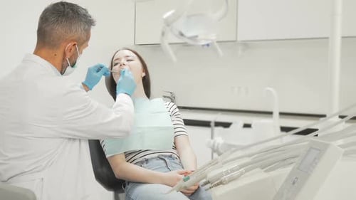 Junge Patientin lässt ihre Zähne vom Zahnarzt untersuchen