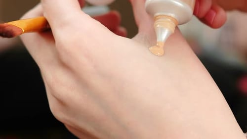 Woman Applies Foundation to Hand for Makeup
