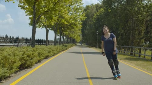 Woman Skating Down Road on Roller Skates