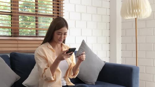 Woman Using Smartphone and Credit Card at Home