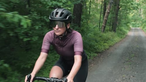 Woman Biking on a Gravel Road in the Forest