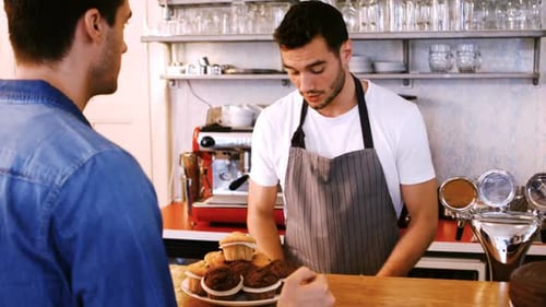 Barista Serving Coffee to Customer at Cafe Counter