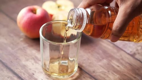 Apple Juice Being Poured into Glass Cup