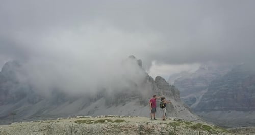 Aerial drone view of a man and woman couple hiking in the mountains