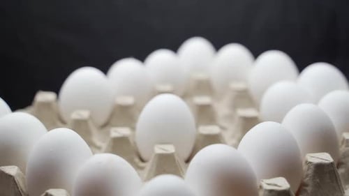 Eggs are getting put into carton tray. Crates of fresh eggs at a poultry farm.