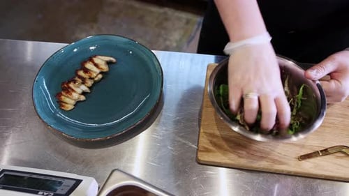 Le chef sert des morceaux de poisson avec salade