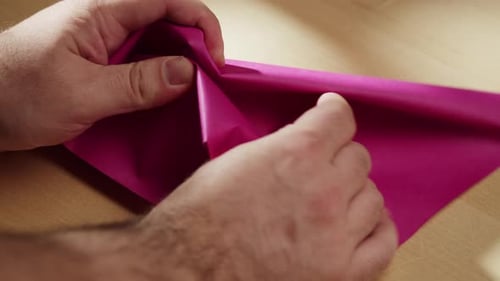 Hands Crumpling Pink Paper Closeup