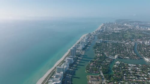 Aerial Panoramic Footage of Ocean Coast with Row of Tall Apartment Buildings Along Beach
