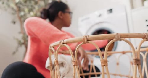 Girl Sits on Bathroom Floor Laundry Room Takes Clothes Out of Wicker Basket Puts in Laundry Spinning