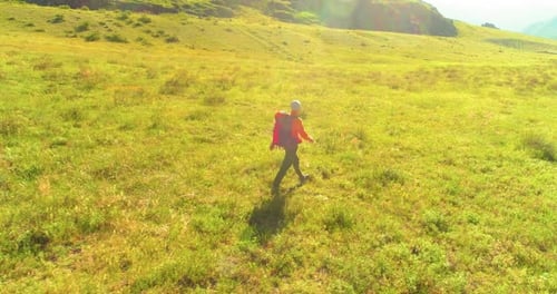 Flight Over Backpack Hiking Tourist Walking Across Green Mountain Field
