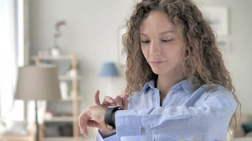 Young Woman Using Smart Watch Indoors