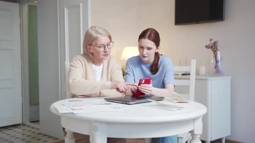 Mature Woman and Young Woman Looking at Smartphone