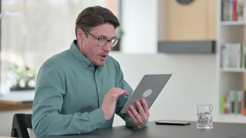 Man Reacting to Good News on Tablet