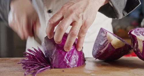 Zeitlupen-Nahaufnahme eines Kochmessers beim Schneiden eines Rotkohls
