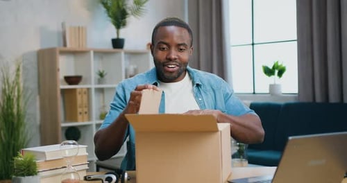 Young Adult Opening a Box with Excitement