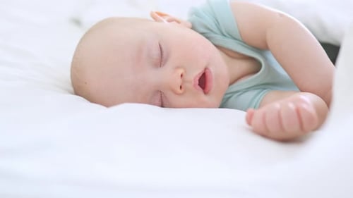 Sweet Baby Sleeping Peacefully on White Bed