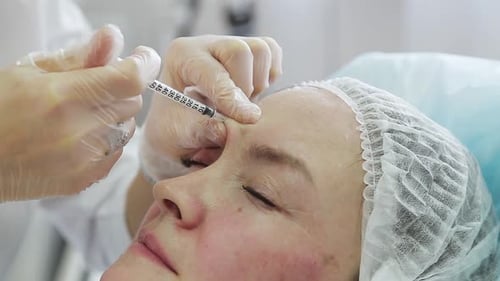 Woman Receives Forehead Injection in Clinic