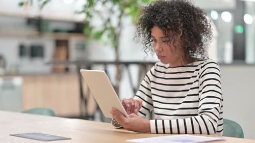 Young African Woman Using Tablet in Office