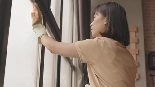 Woman Cleaning Window With Rag in Modern Home