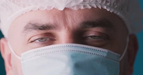 Portrait en gros plan d'un médecin portant un masque médical de protection et une casquette jetable