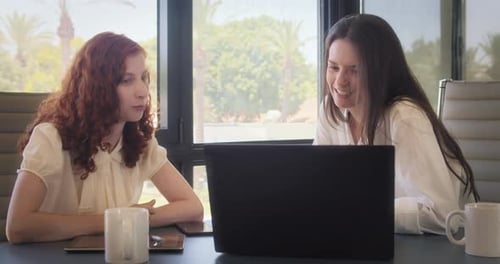 Two Young Adults Working in Office