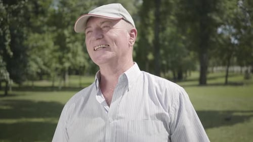 Portrait Confident Old Man in a Cap Looking Away Smiling Waiting for His Friend in the Park