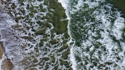 Aerial Drone View Flight Over Sea Waves That Roll Onto Sandy Shore