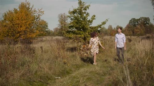 Young Couple Walking on a Meadow