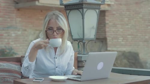 Business Woman Working On Laptop And Drink Coffee In Cafe