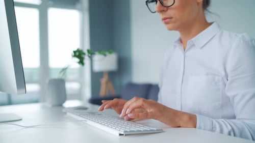 Woman Typing on Computer Keyboard in Office