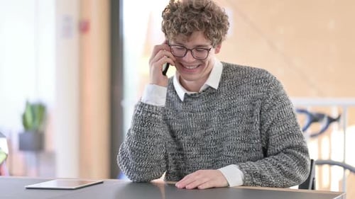 Young Adult Talking on Mobile Phone Indoors
