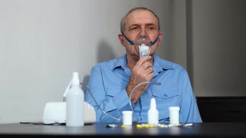 Homme âgé malade utilisant un traitement par nébuliseur