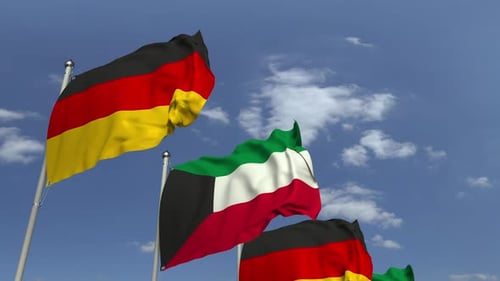 Waving Flags of Kuwait and Germany Against Blue Sky
