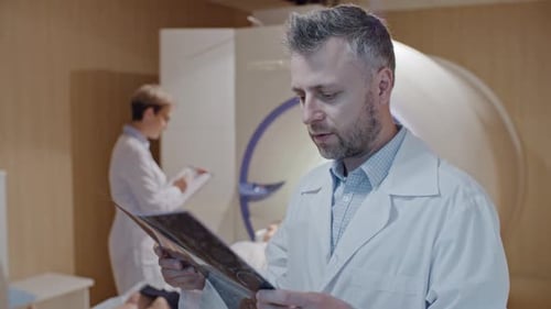 Doctor Analyzes Brain Scan in Hospital MRI Room