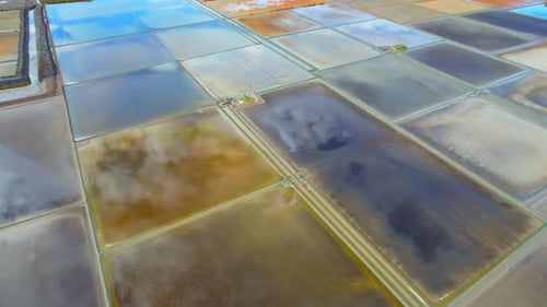 An aerial view from a drone flying over a salt fields, salt production.