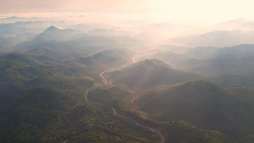 4K Scenic flight over beautiful mountain scape with bright sky and clouds