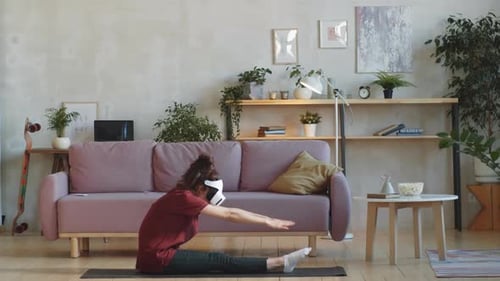 Woman Stretching at Home with VR Headset