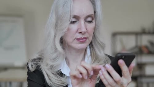 Woman with Gray Hair Using Mobile Phone
