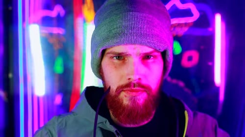 Man with Prosthetic Puts on Sunglasses in Neon Lighting