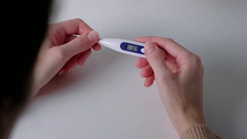 Hands Hold Thermometer Reading High Temperature