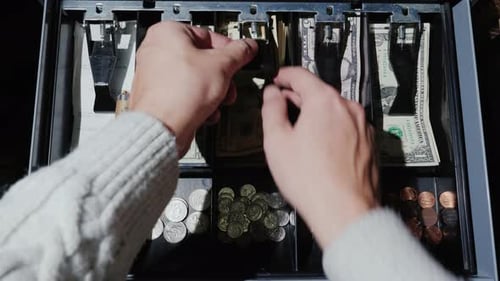 Vídeo POV: El cajero pone el dinero en la caja registradora y se lleva el cambio. Venta minorista por efectivo en EE.